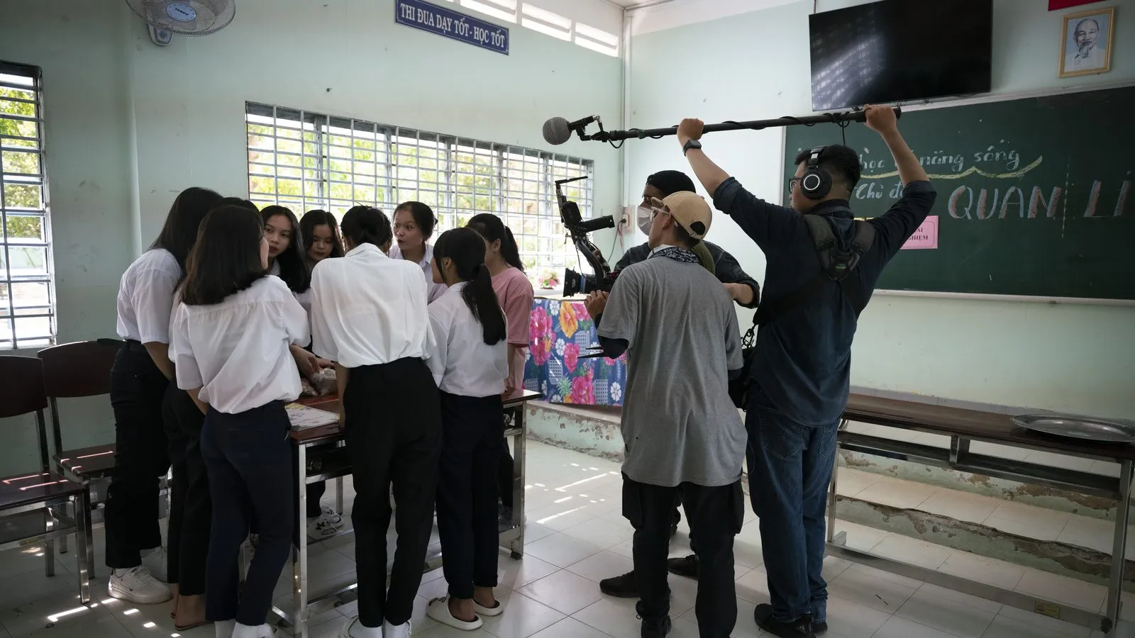 Crew on a ladder with a boom mic filming a classroom in Vietnam