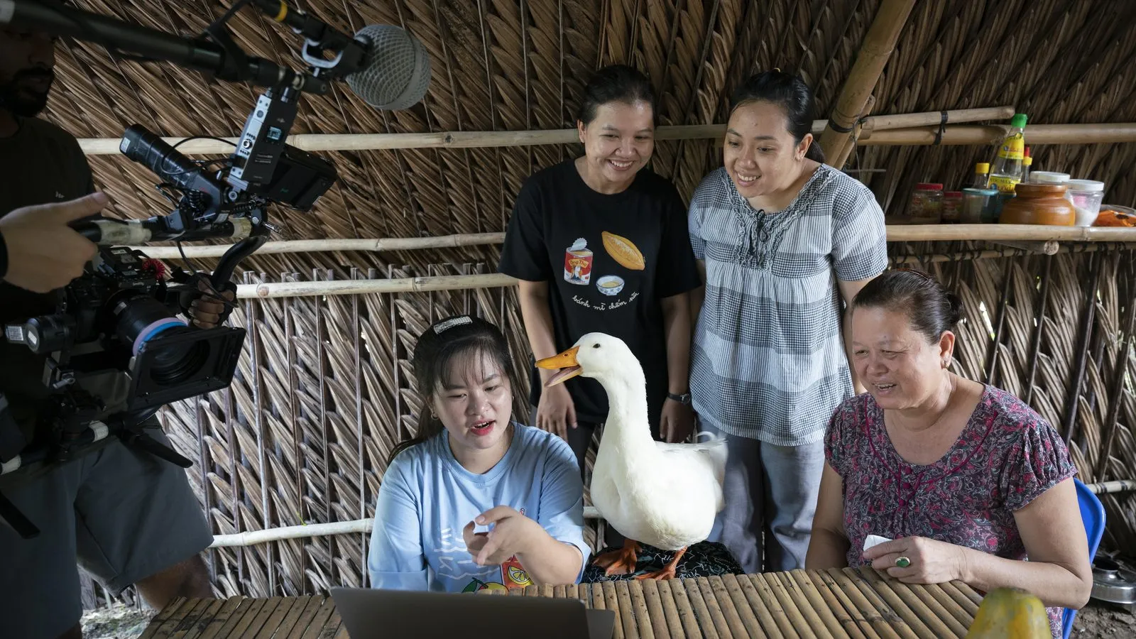 Crew gathered with a family and their pet goose in Vietnam