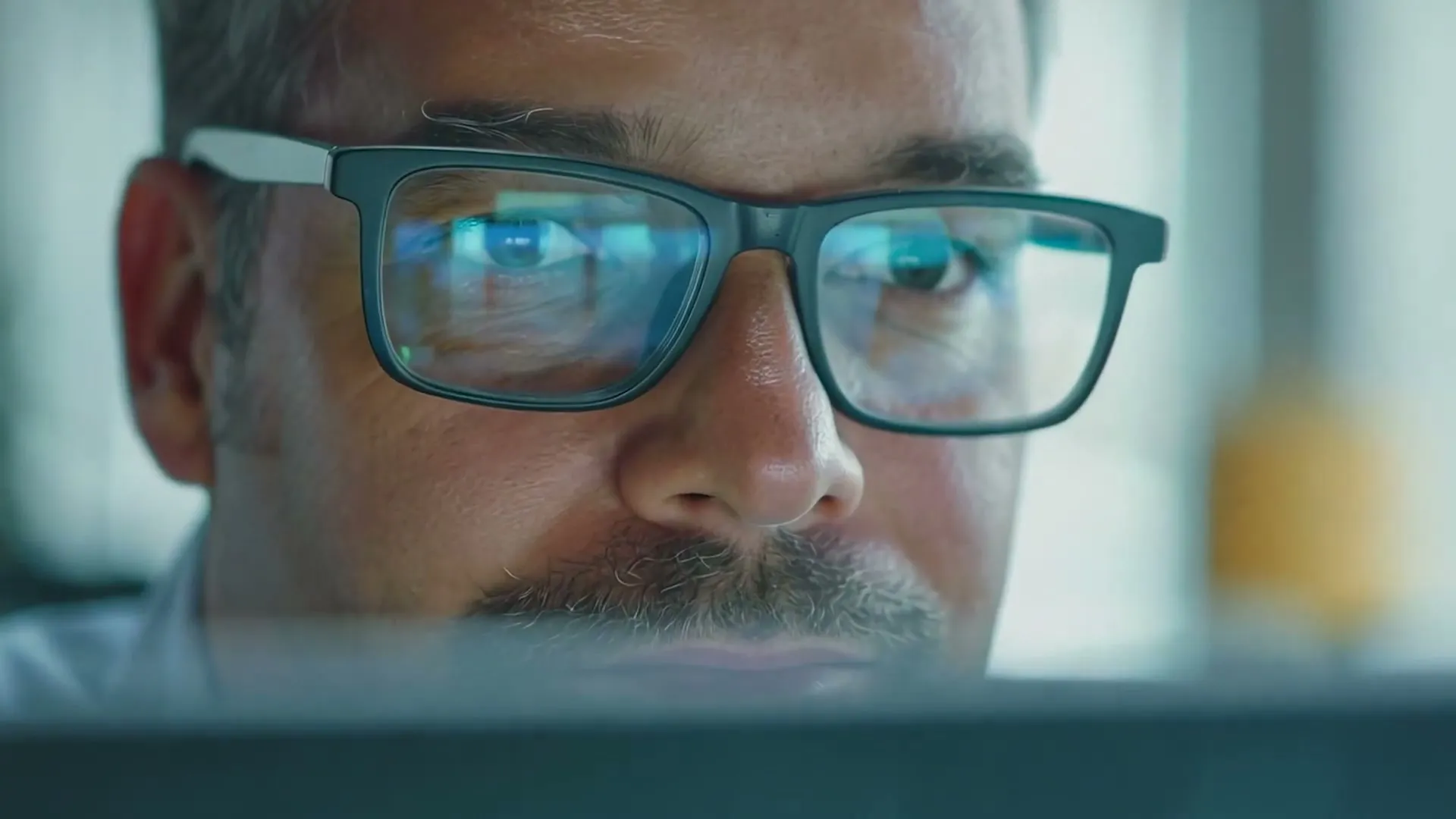 Close-up of a security analyst in glasses, a dashboard reflected in the lenses, from the KnowBe4 AIDA explainer