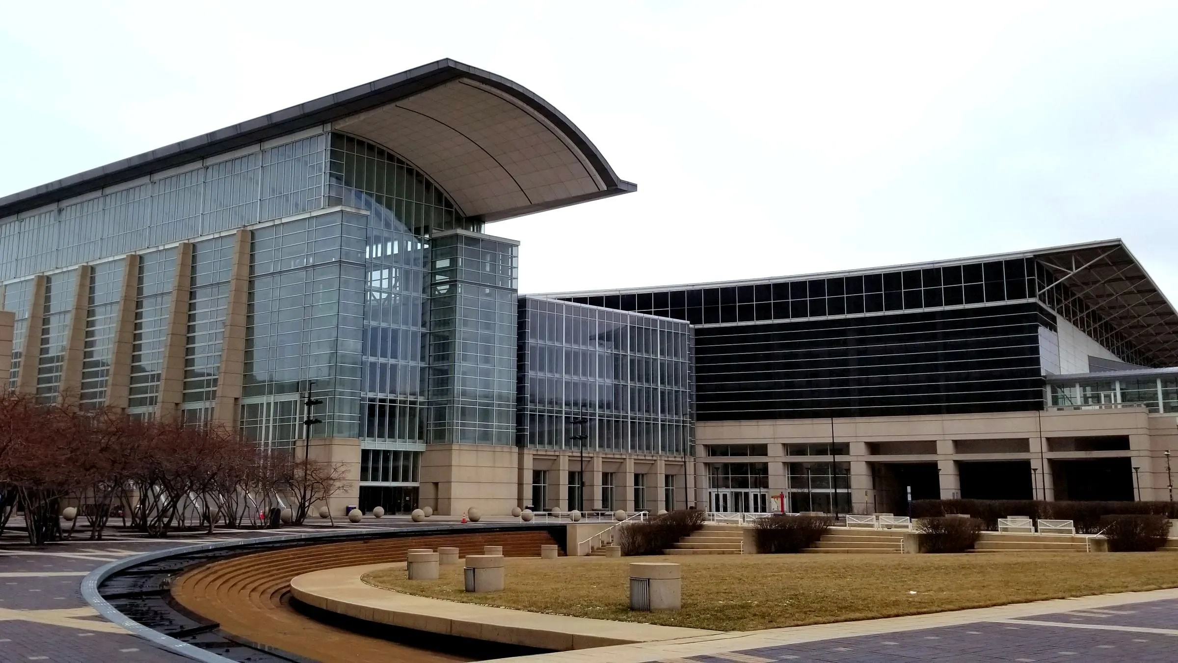 The glass and steel entrance of McCormick Place in Chicago under a curved roof, with the plaza in front