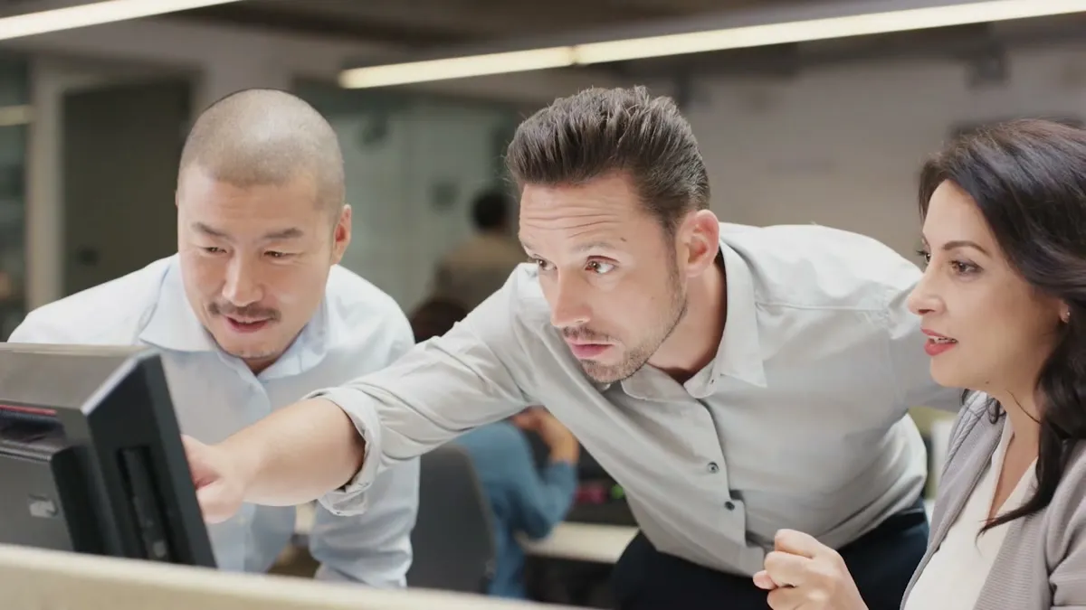 Three coworkers huddled around a monitor, one pointing at the screen, from a LogRhythm 30-second spot