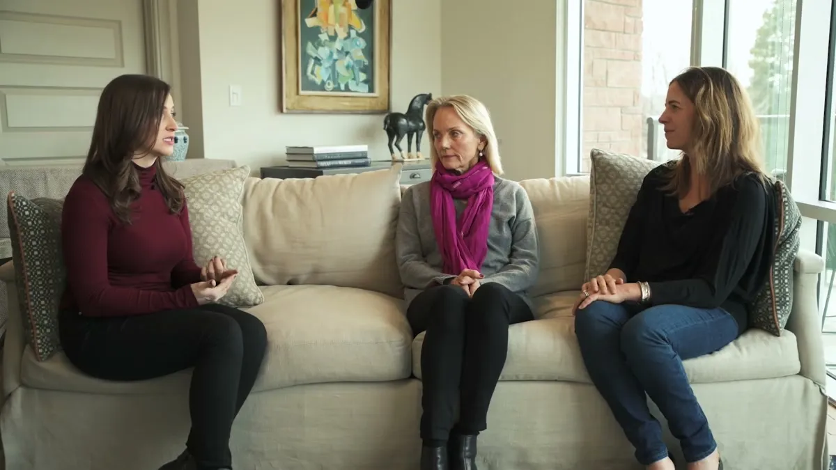 Three women in conversation on a couch in a bright living room, from the Curable customer story