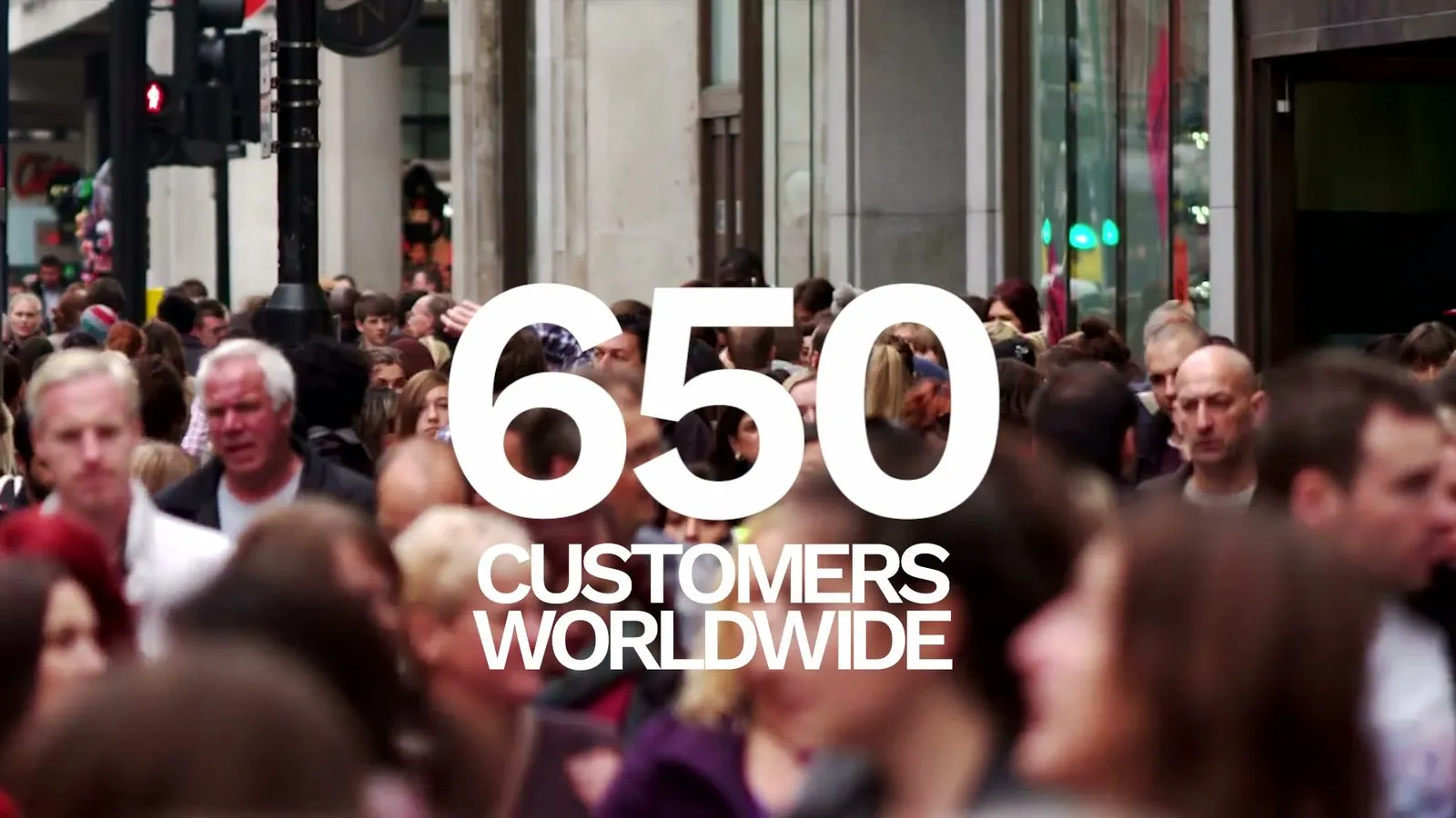 Frame from the Securonix sales kickoff film: "650 customers worldwide" in large type over a street crowd